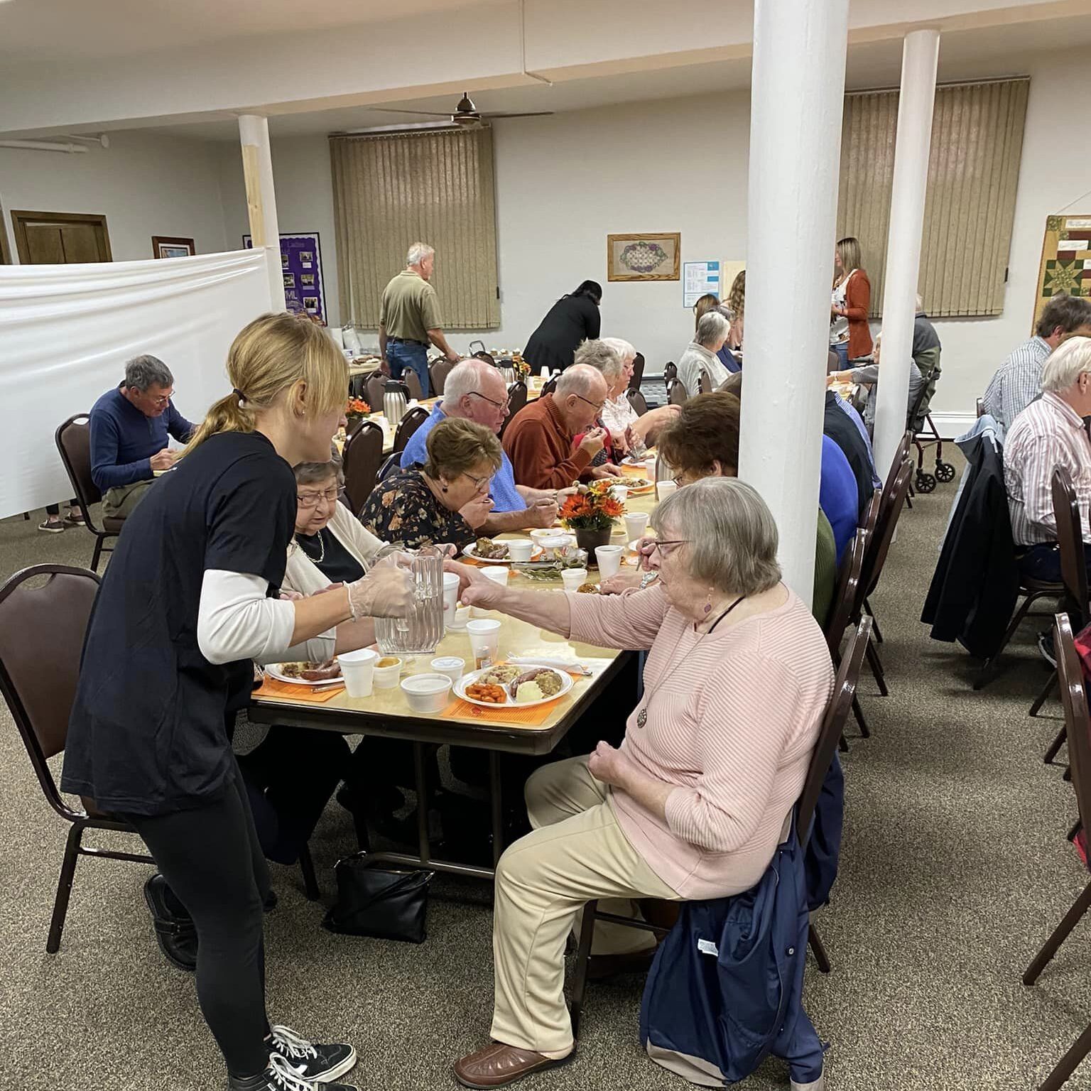 table full of people eating in church basement