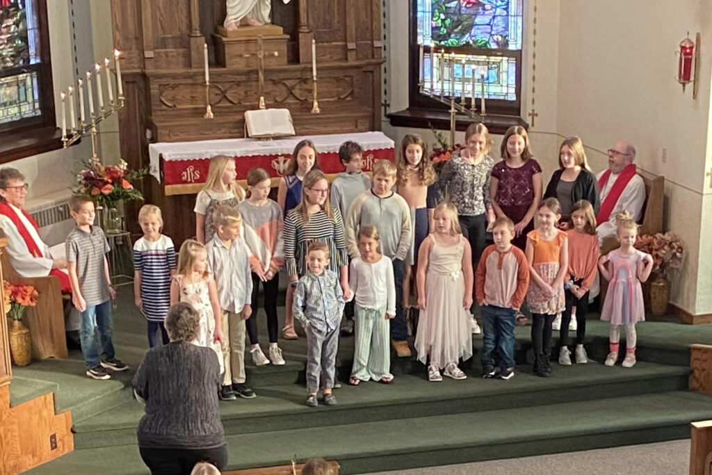 group of children singing at the front of the church