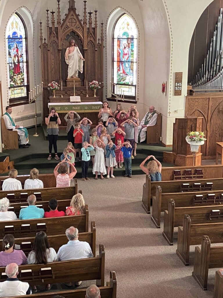 group of young children singing and posing from the front of church