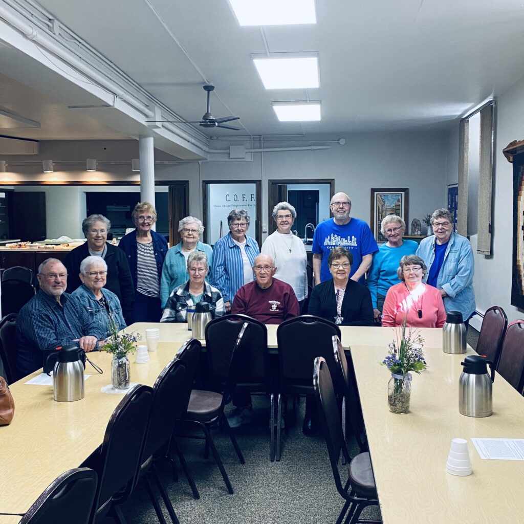 group of men and women near two tables in church basement